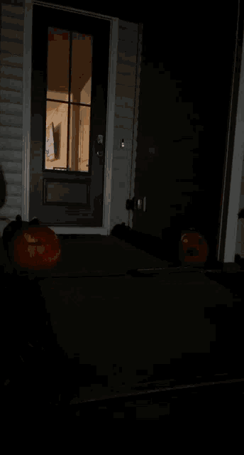 two carved pumpkins are lit up in front of a doorway