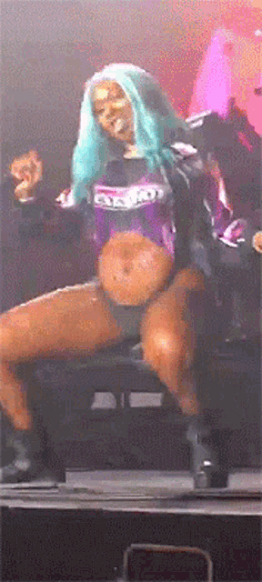 a woman with blue hair is dancing on a stage while wearing a shirt that says ' dirty ' on it