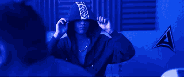 a person wearing a hoodie with the letter a on the wall