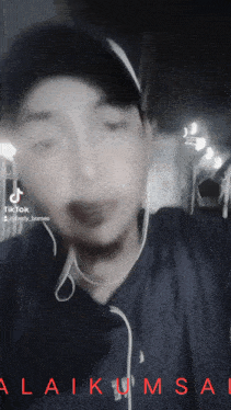 a man wearing headphones and a hat has tiktok written on the bottom