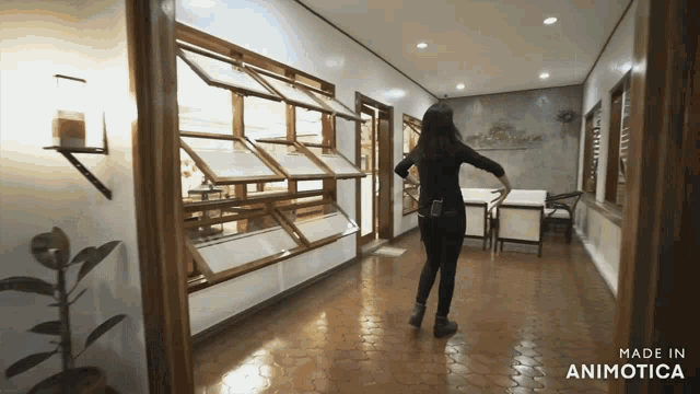 a woman is dancing in a hallway with the words made in animotica below her