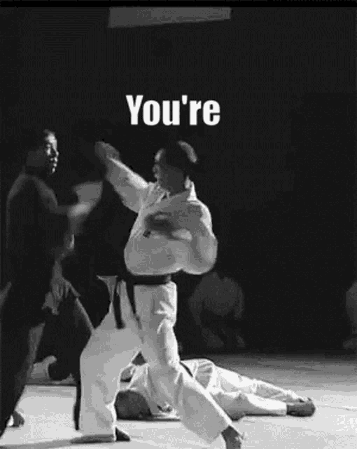 a black and white photo of a karate match with the words `` you 're '' on the bottom .