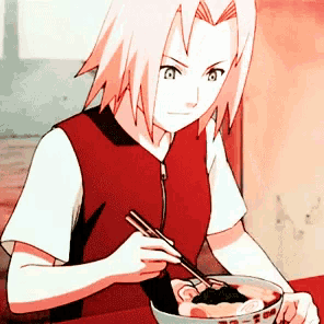 a girl with pink hair is sitting at a table eating a bowl of food with chopsticks