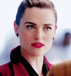 a close up of a woman wearing red lipstick and a red coat .
