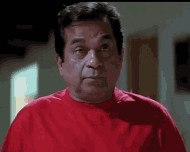 a man wearing a red shirt with twitter @bhibatsam written on it