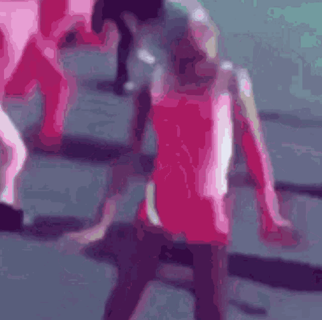 a blurry picture of a person in a pink shirt dancing