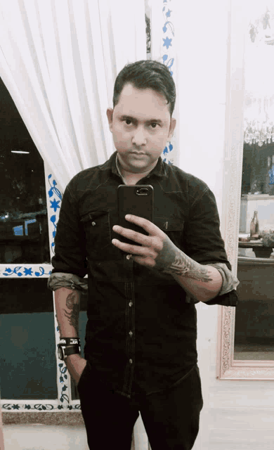 a man taking a picture of himself in front of a window
