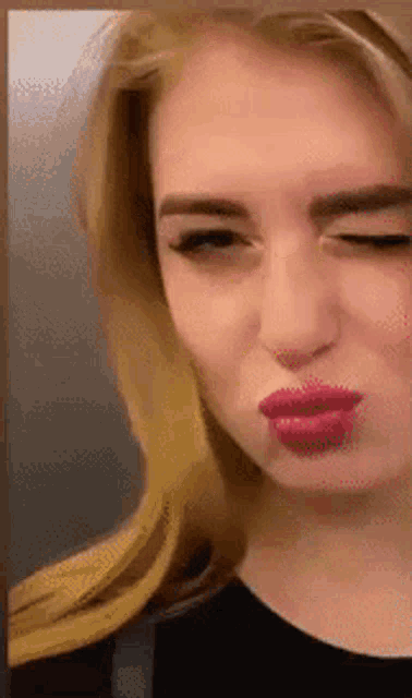 a close up of a woman making a face with her eyes closed