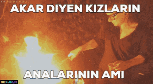 a woman is standing in front of a fire with the words akar diyen kizlarin analarinin ami