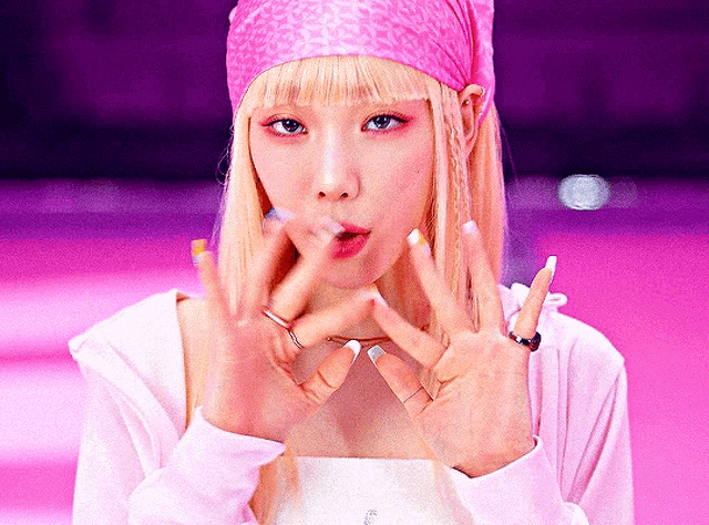 a woman with blonde hair wearing a pink head scarf and rings on her fingers