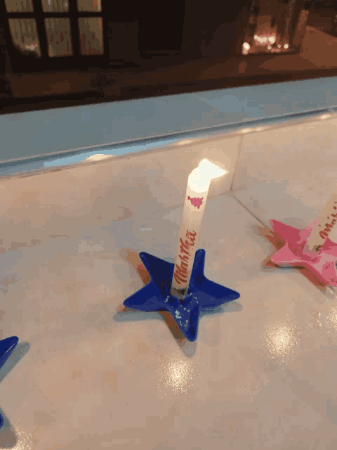 a candle in a star shaped holder that says " thank you "