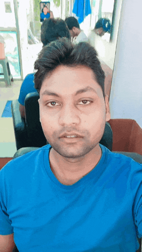 a man in a blue shirt takes a selfie