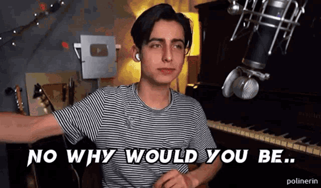 a young man in a striped shirt says " no why would you be " in front of a microphone