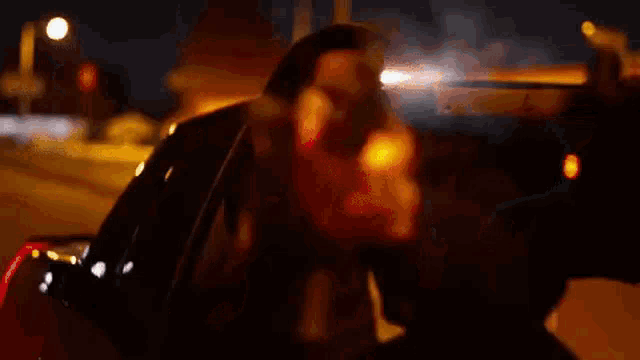 a man in a hooded jacket is pointing a gun at the camera .