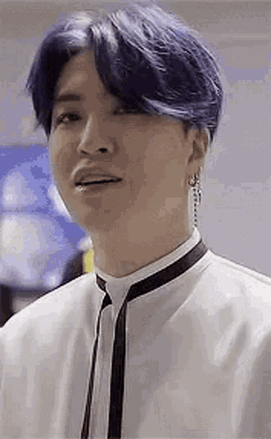 a close up of a person wearing a white shirt and tie with blue hair .