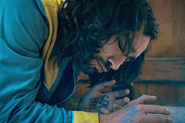 a man with long hair and a tattoo on his hand that says 6006 bye