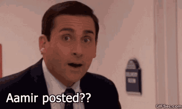 a man in a suit and tie is making a surprised face and says aamir posted ?