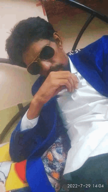 a man wearing sunglasses and a blue jacket has the date 2022-7-29 14:04 on the bottom