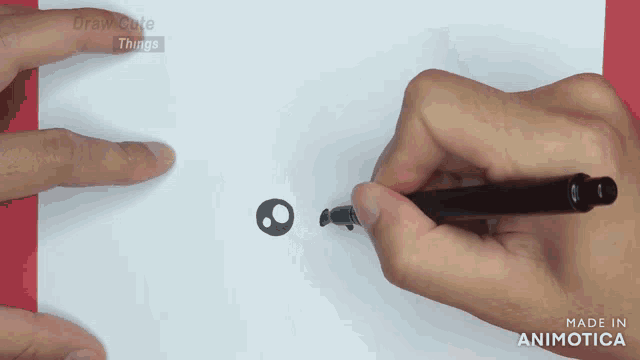 a person is drawing a circle on a piece of paper with the words draw cute things in the background