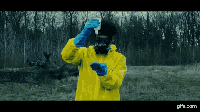 a man in a yellow suit and blue gloves holds a piece of paper in his hand