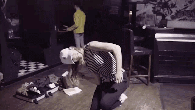 a woman wearing a virtual reality headset is squatting on the floor .