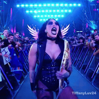 a woman in a black and gold outfit is screaming in front of a crowd with tiffanyluv24 on the bottom right