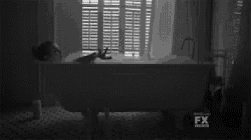 a black and white photo of a person in a bathtub with fx written on the bottom right