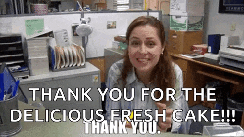 a woman is sitting at a desk in an office saying `` thank you for the delicious fresh cake ! ''
