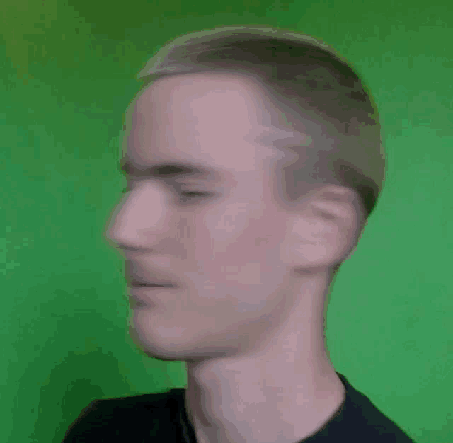 a blurry picture of a man 's face against a green background .