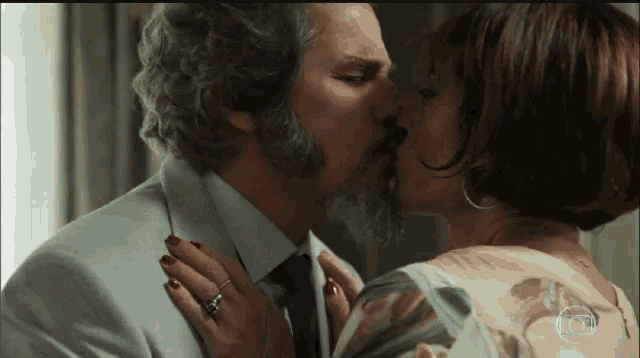 a man and a woman are kissing and the woman is wearing red nails