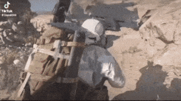 a man in a helmet is holding a gun in a video game .
