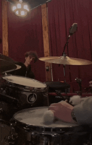 a man is playing drums in a room with a nord stage