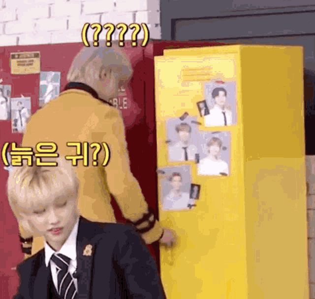 a man in a suit is standing next to a yellow locker .