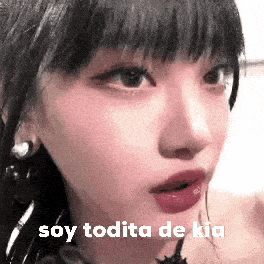 a close up of a woman 's face with the words `` soy todita de kia '' written above her .