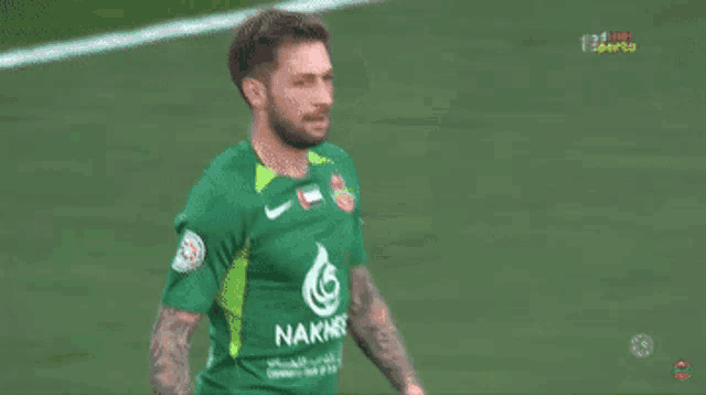 two soccer players wearing green jerseys with the number 5 on them