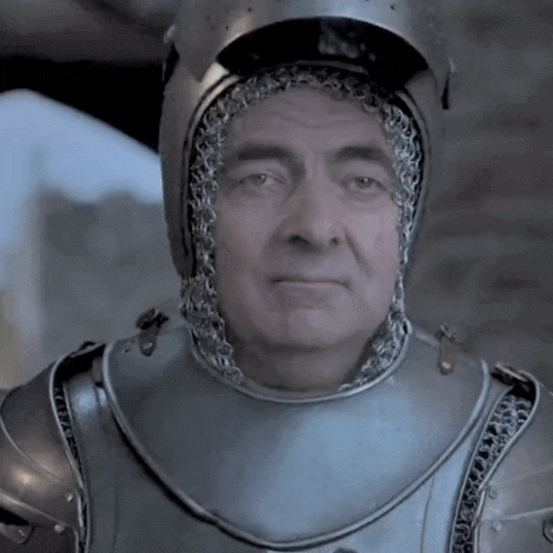 a man in armor with a helmet on his head looks at the camera