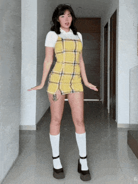 a woman in a yellow plaid dress and white socks