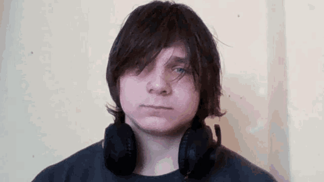 a young man is wearing headphones around his neck .