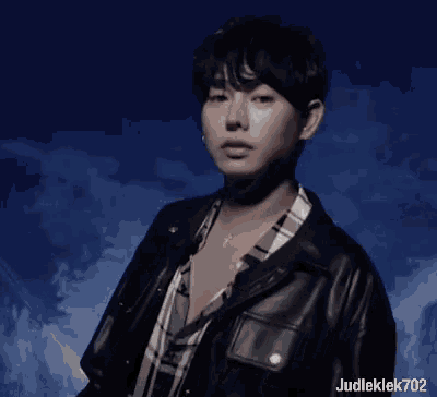 a man wearing a plaid shirt and a leather jacket with judleklek702 on the bottom
