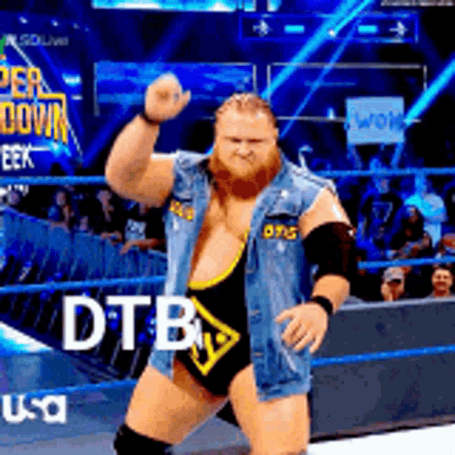 a man in a wrestling ring with the word dtb on the bottom of his chest