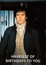 a man in a suit is standing in front of a door with the words `` happiest of birthdays to you '' .