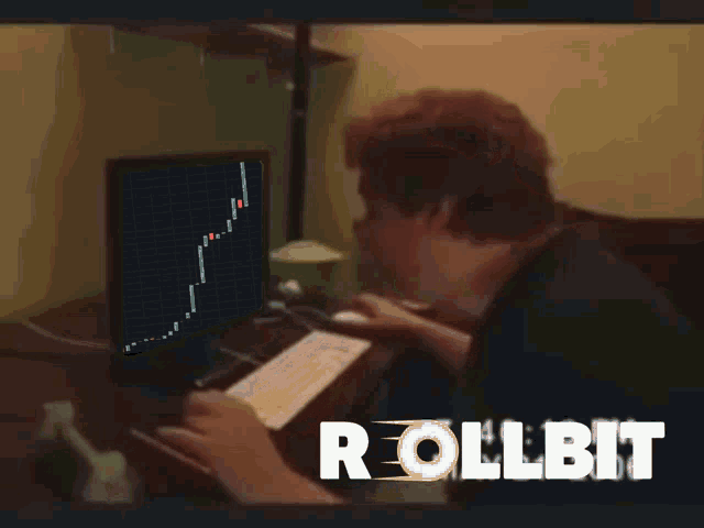 a man sitting in front of a computer with the word rollbit on the bottom right