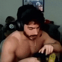 a shirtless man wearing headphones is sitting in a room .