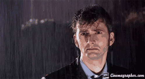 a man in a suit is crying in the rain
