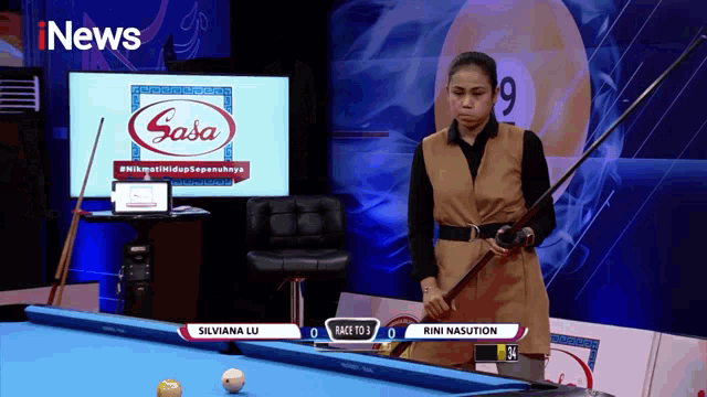 a woman holding a pool cue stands in front of a screen that says inews