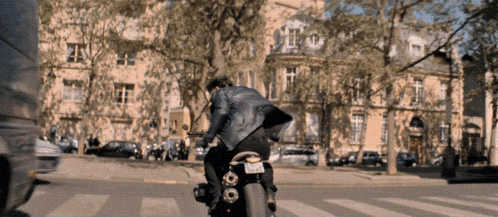 a man is riding a motorcycle down a street with a license plate that says ' jcw ' on it