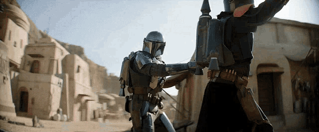 two soldiers in armor are standing next to each other in a desert town