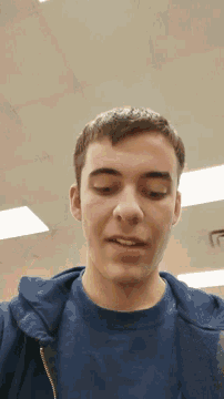 a man wearing a blue shirt is smiling and looking at the camera