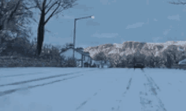 a truck is driving down a snow covered street .