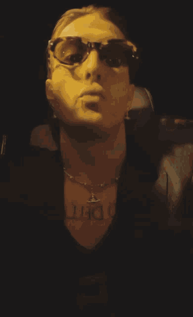 a man wearing sunglasses and a necklace that says o det